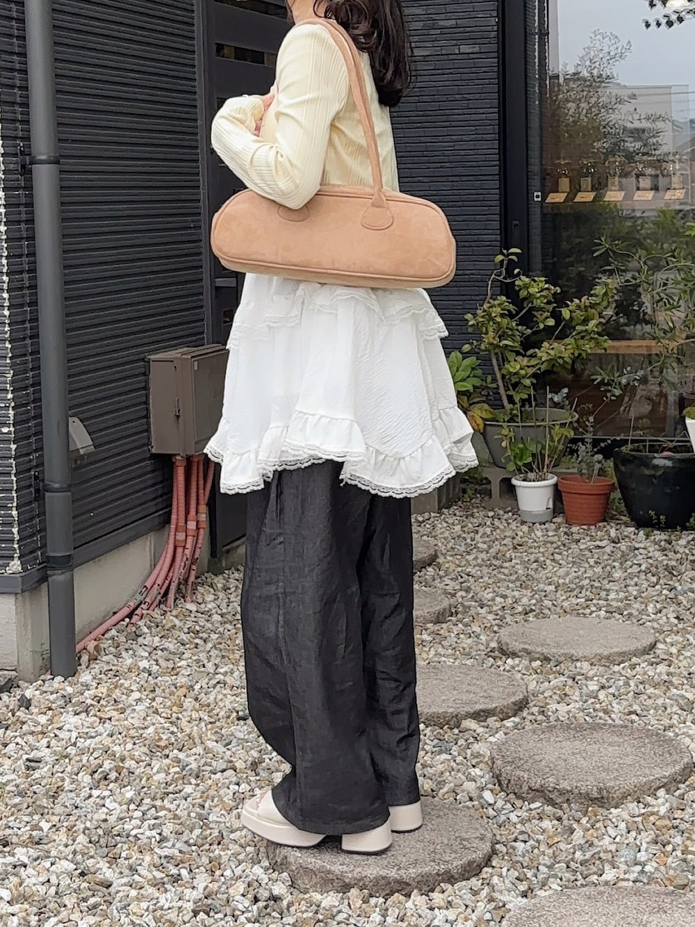 ベージュ系のボストンバッグ、ホワイト系のワンピース/ドレス、イエロー系のカーディガン/ボレロを着用したレディースの春コーディネートの1枚目の写真