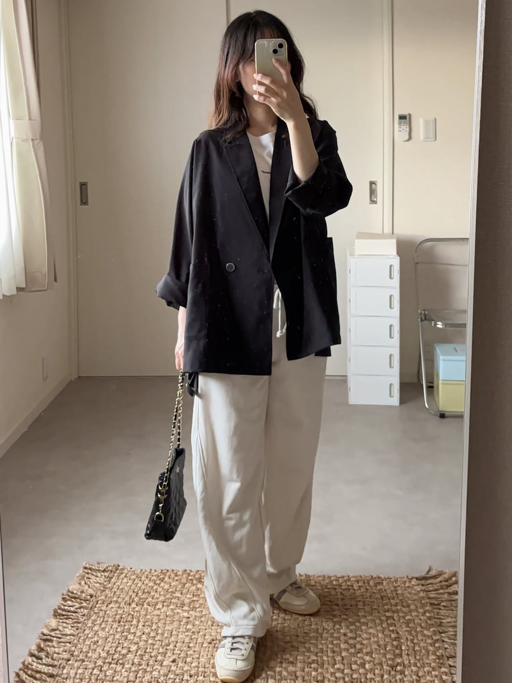 ブラック系のテーラードジャケット、ホワイト系のTシャツ/カットソー、ブラック系のショルダーバッグを着用したレディースの秋コーディネートの1枚目の写真