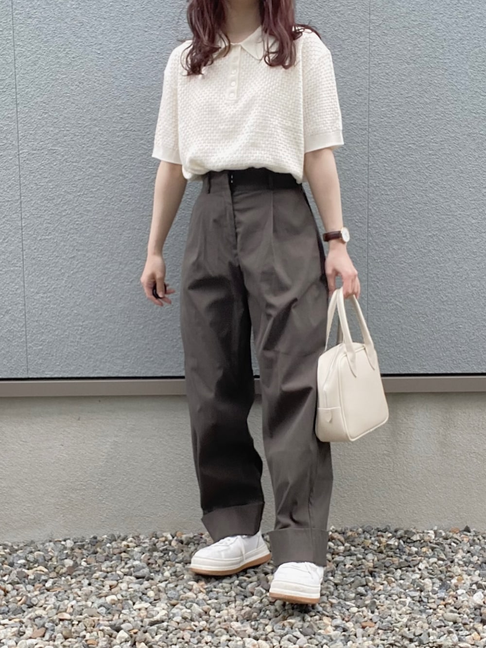 ホワイト系のポロシャツ、グレー系のチノパンツ、ホワイト系のスニーカーを着用したレディースの夏コーディネートの1枚目の写真