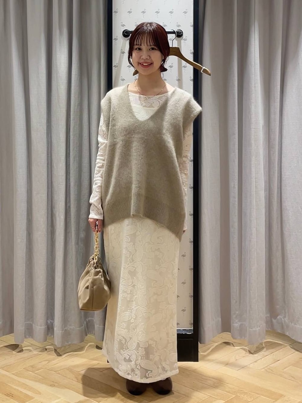 ベージュ系のベスト、ブラウン系のバレエシューズ、ベージュ系のショルダーバッグを着用したレディースの秋コーディネートの1枚目の写真