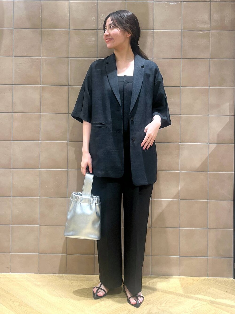 ブラック系のサロペット/オーバーオール、ブラック系のテーラードジャケット、ブラック系のサンダルを着用したレディースの春コーディネートの1枚目の写真