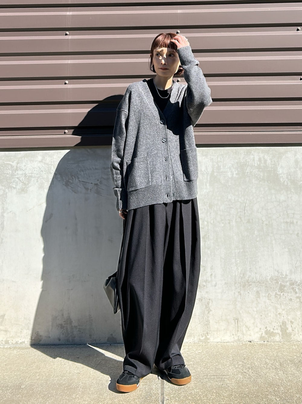 グレー系のカーディガン/ボレロ、グレー系のパンツを着用したレディースの秋コーディネートの1枚目の写真