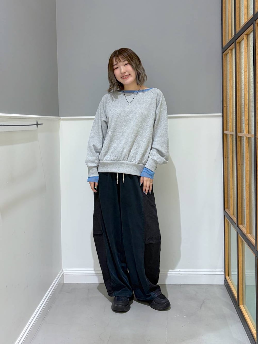 ブルー系のデニムパンツ、グレー系のその他トップス、ブラック系のスニーカーを着用したレディースの秋コーディネートの1枚目の写真