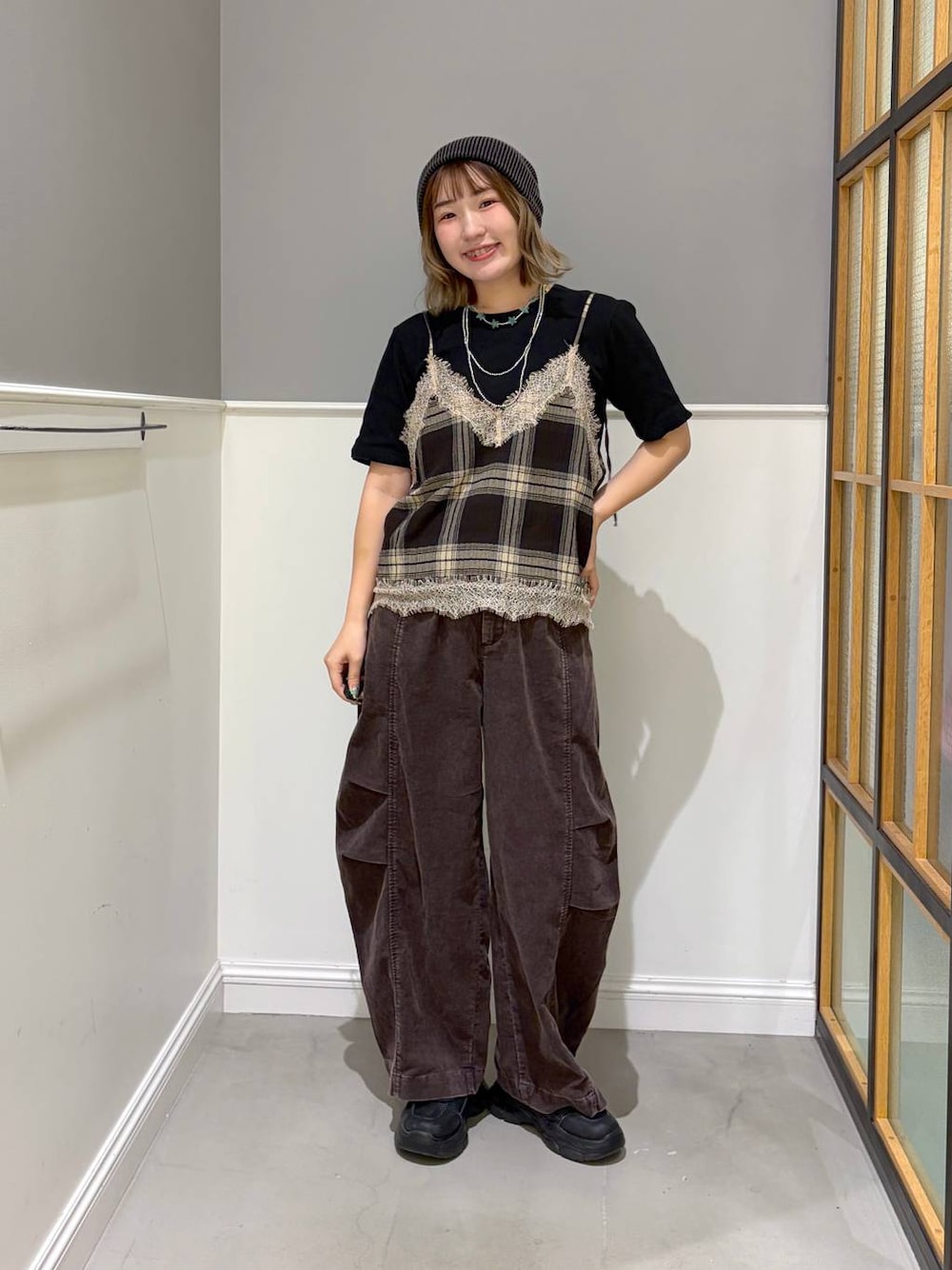 ブラウン系のその他パンツ、ブラウン系のキャミソール、ブラック系のスニーカーを着用したレディースの秋コーディネートの1枚目の写真