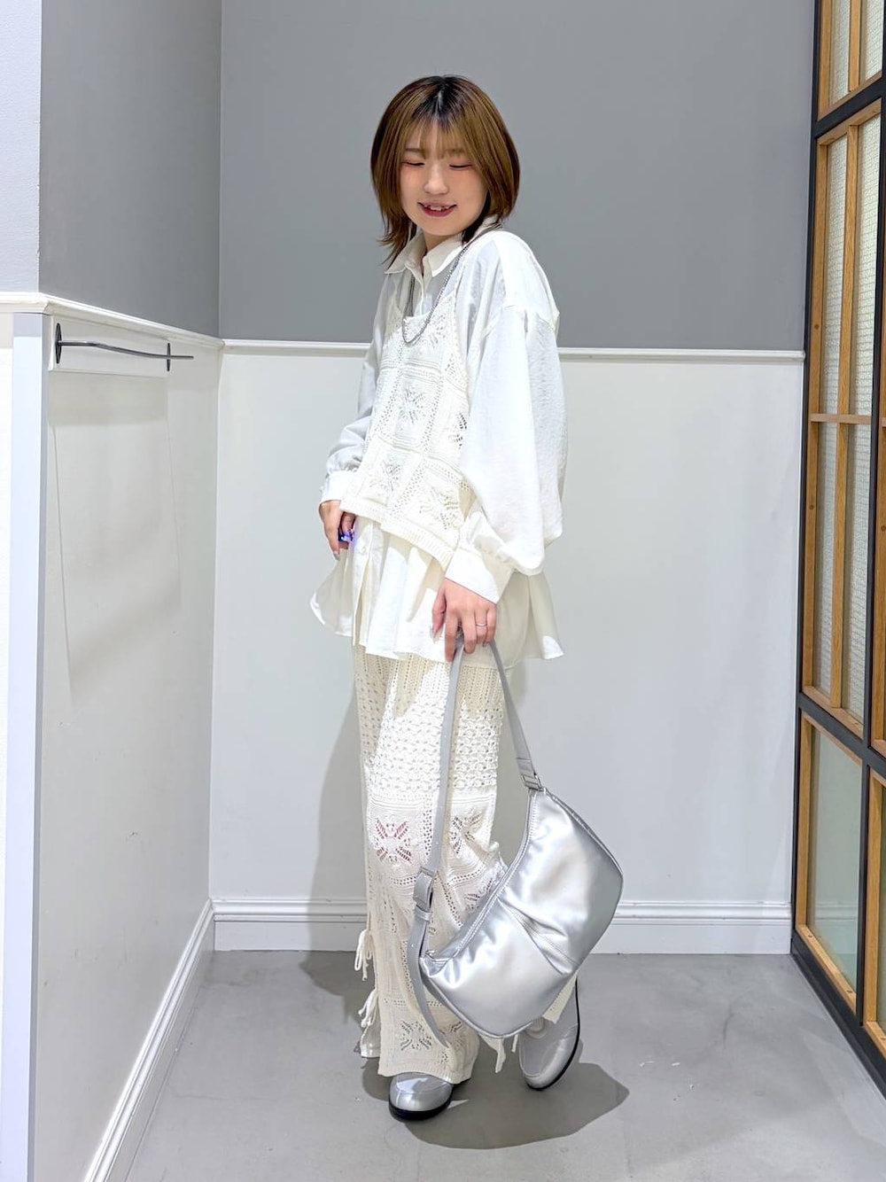 シルバー系のショルダーバッグ、ホワイト系のシャツ/ブラウス、シルバー系のパンプスを着用したレディースの冬コーディネートの1枚目の写真