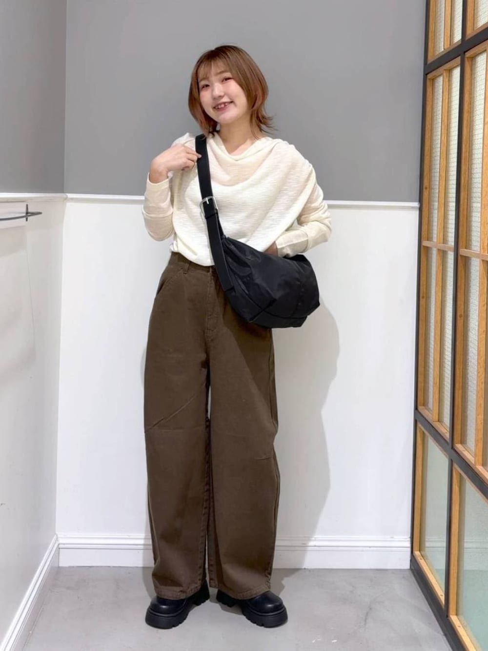 グリーン系のその他パンツ、ブラック系のその他シューズ、ブラック系のショルダーバッグを着用したレディースの春コーディネートの1枚目の写真