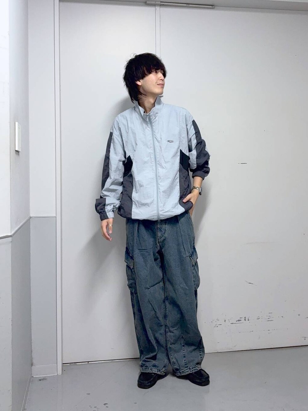 ブルー系のデニムパンツ、グレー系のブルゾンを着用したメンズの秋コーディネートの1枚目の写真