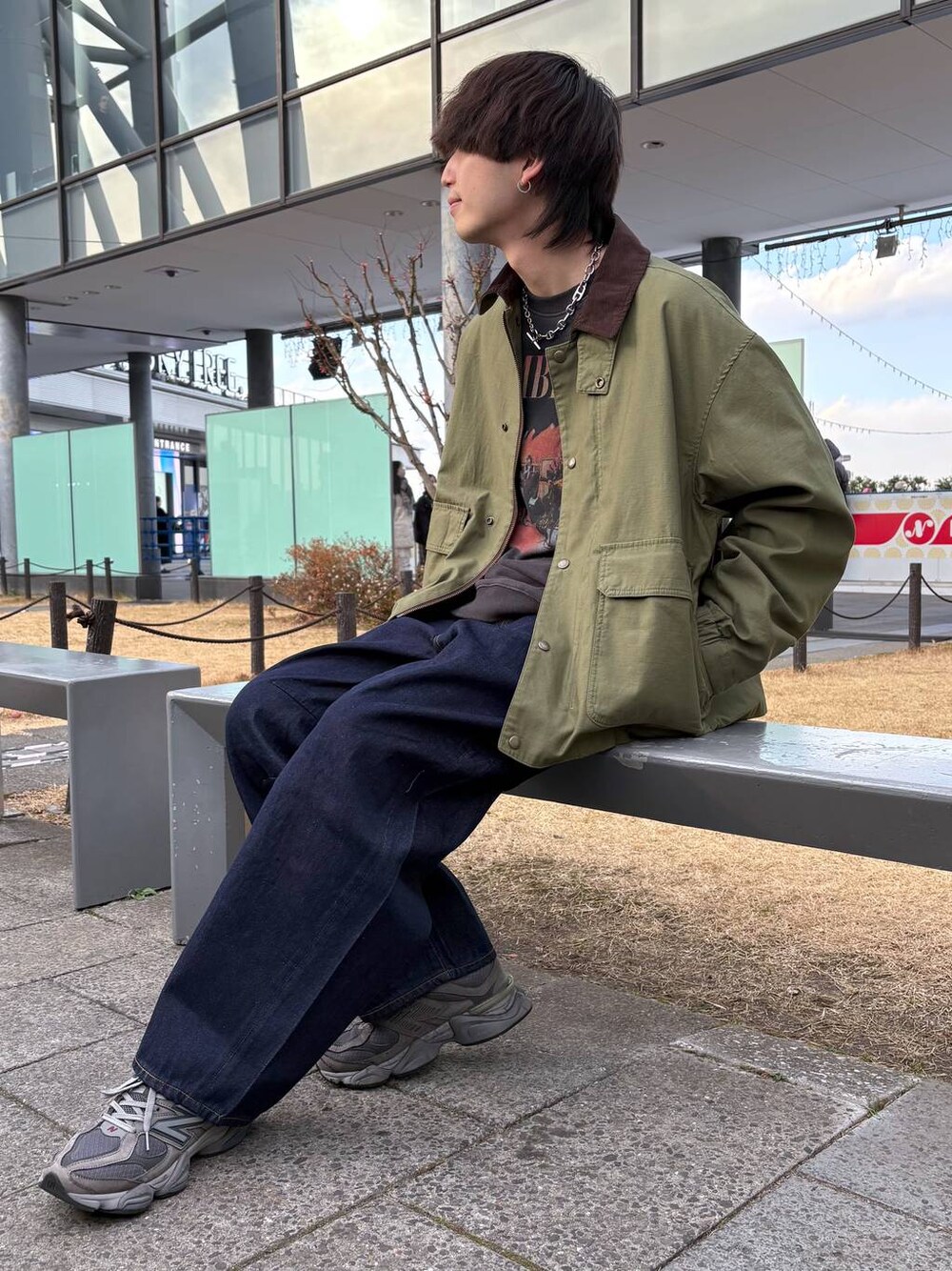 グリーン系のブルゾン、ブルー系のデニムパンツ、ブラック系のスウェットを着用したメンズの冬コーディネートの1枚目の写真