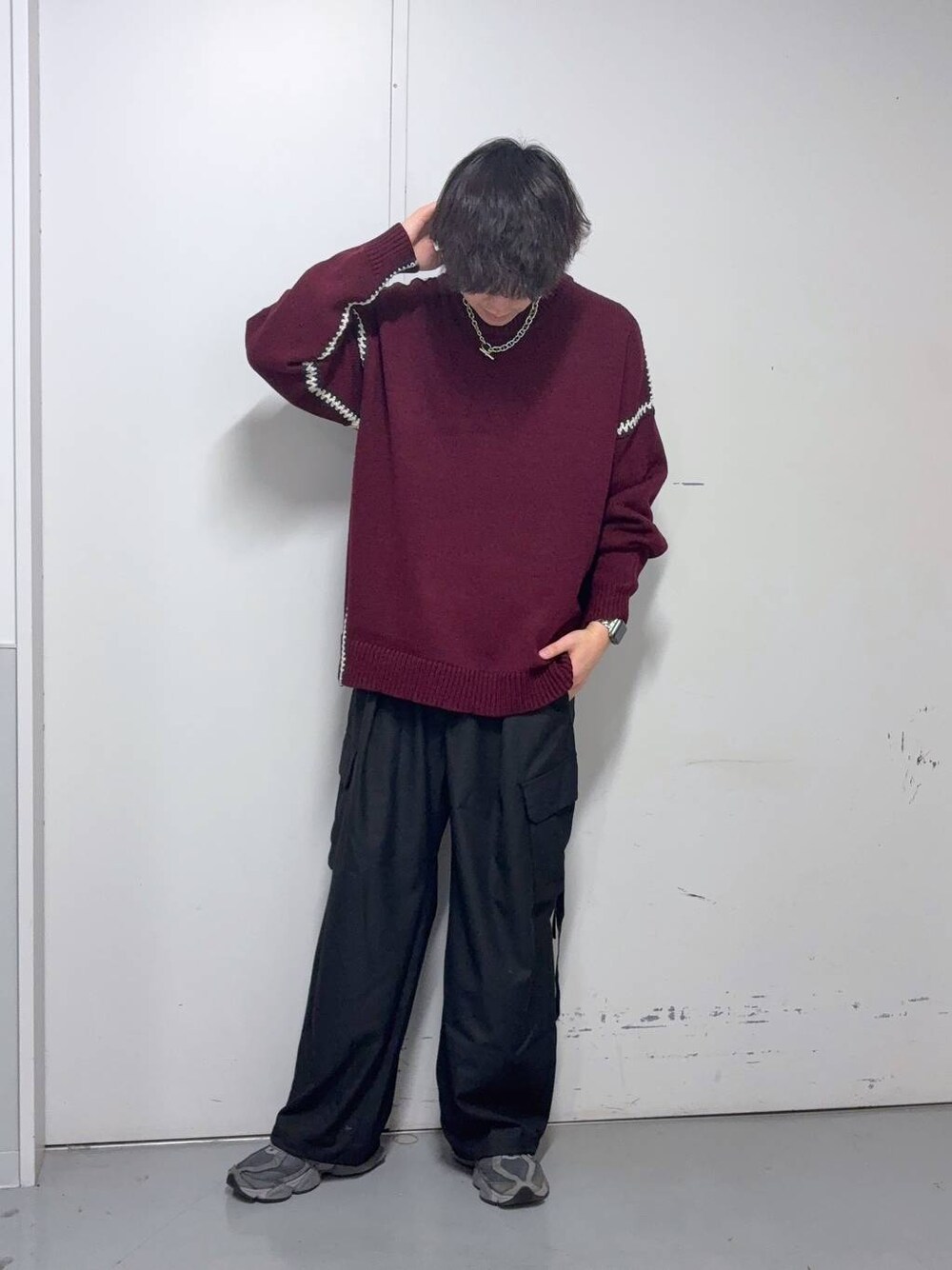 レッド系のニット/セーター、ブラック系のスラックス、ブルー系のソックス/靴下を着用したメンズの冬コーディネートの1枚目の写真