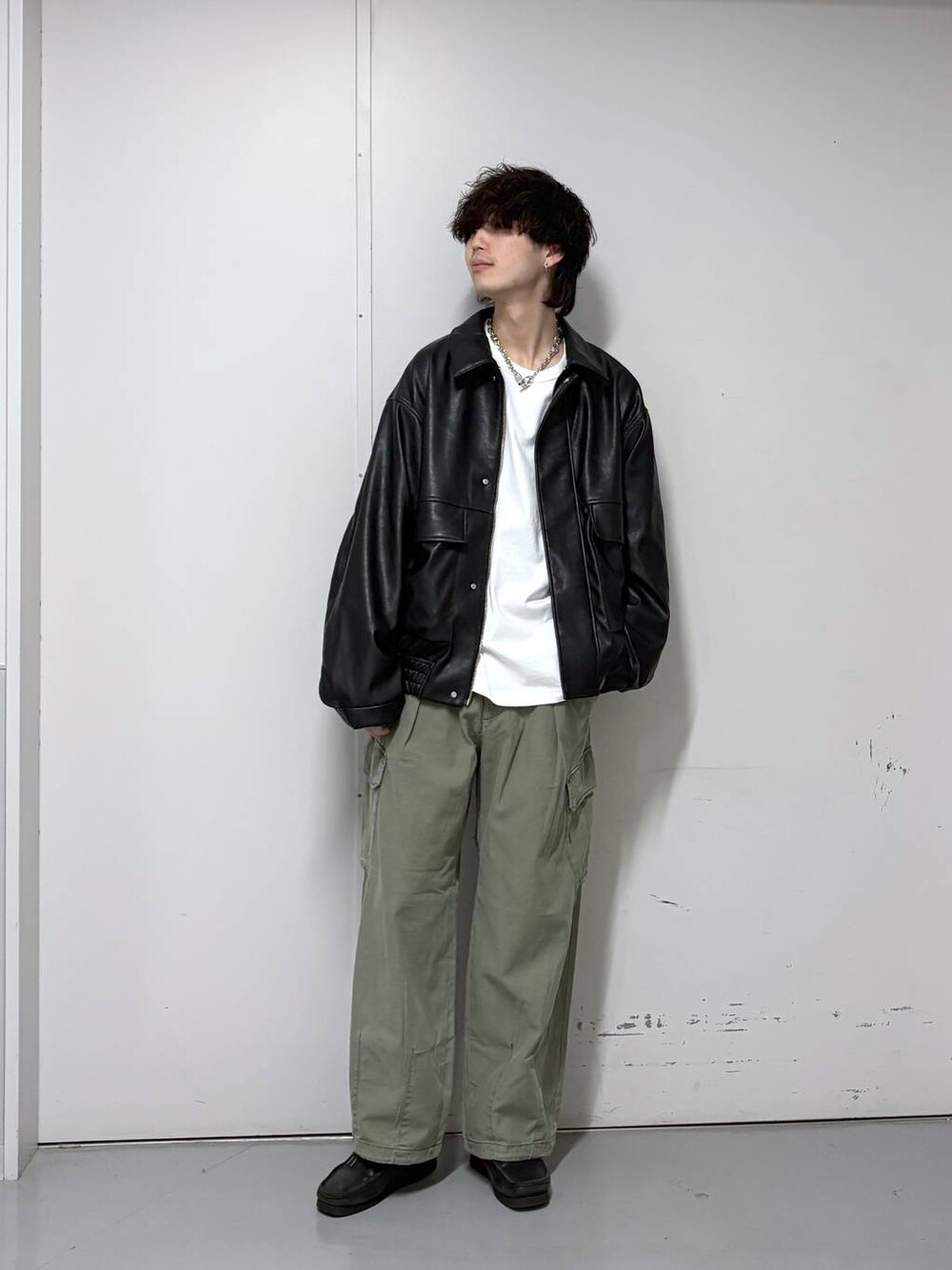 ブラック系のブルゾン、グリーン系のカーゴパンツ、ホワイト系のTシャツ/カットソーを着用したメンズの春コーディネートの1枚目の写真