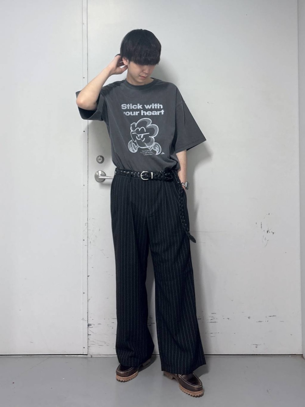 ブラック系のスラックス、グレー系のTシャツ/カットソー、ブラック系のベルトを着用したメンズの春コーディネートの1枚目の写真