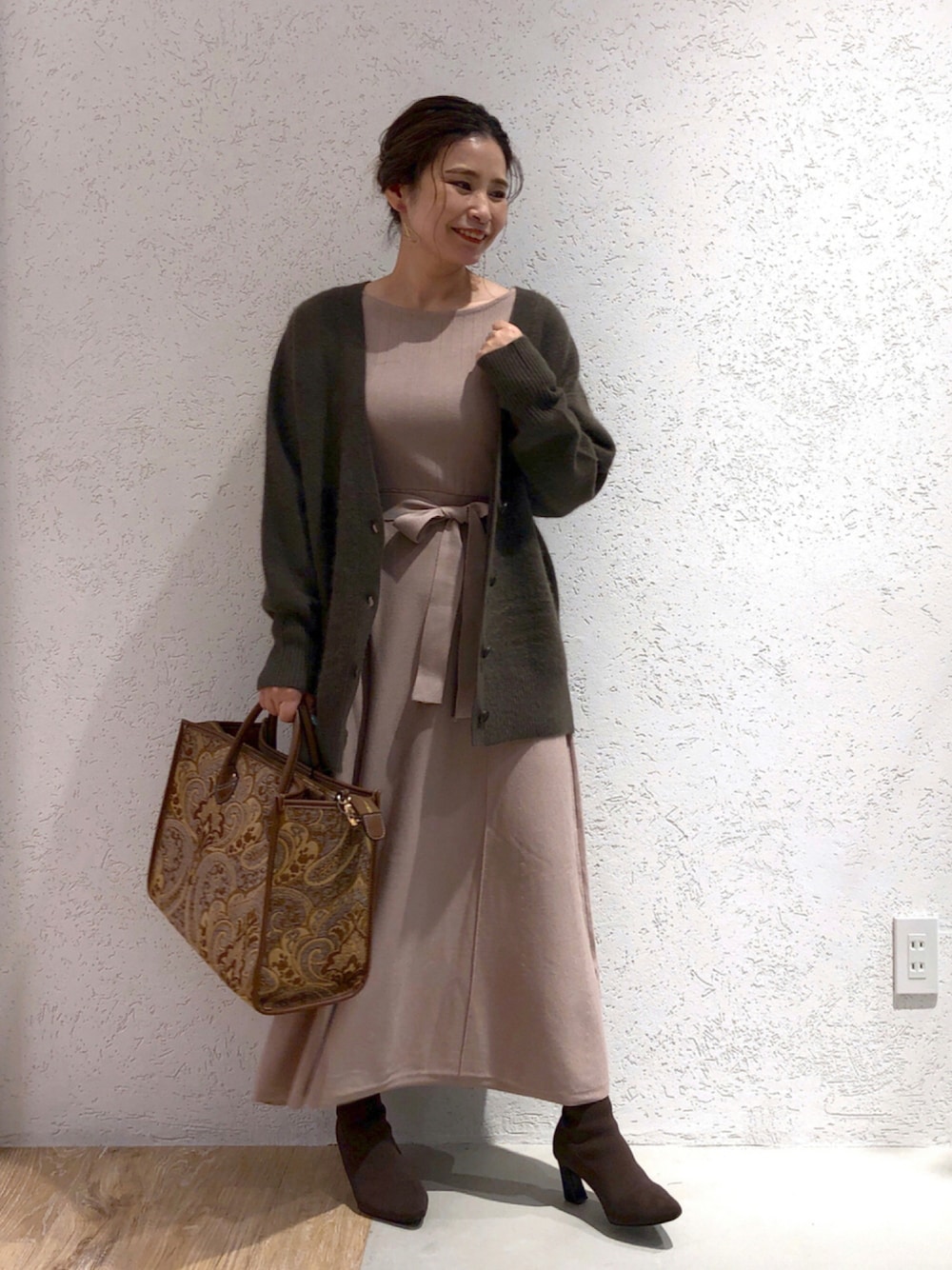 ベージュ系のワンピース、ブラウン系のニット/セーター、ブラウン系のトートバッグを着用したレディースの秋コーディネートの1枚目の写真