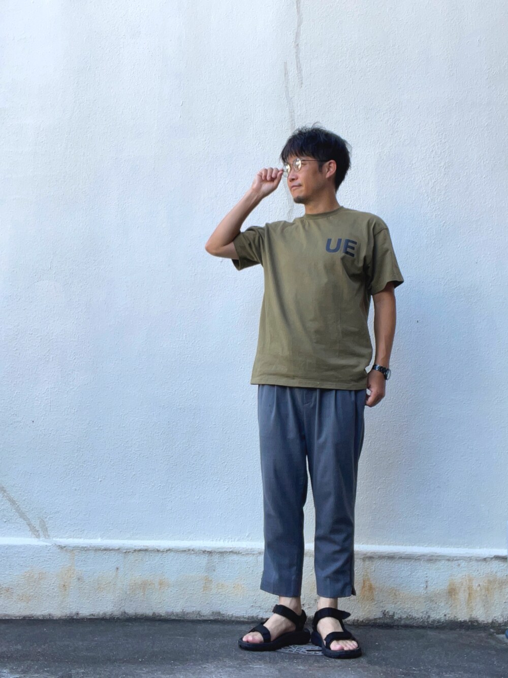 グリーン系のTシャツ/カットソー、グレー系のその他パンツ、ブラック系のサンダルを着用したメンズの夏コーディネートの1枚目の写真