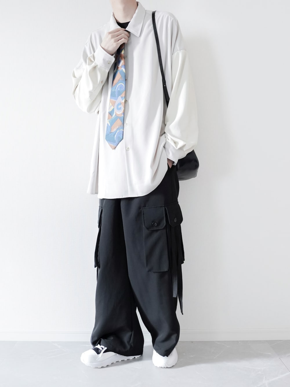ホワイト系のシャツ/ブラウス、ブラック系のカーゴパンツ、ブラック系のスニーカーを着用したメンズの春コーディネートの1枚目の写真