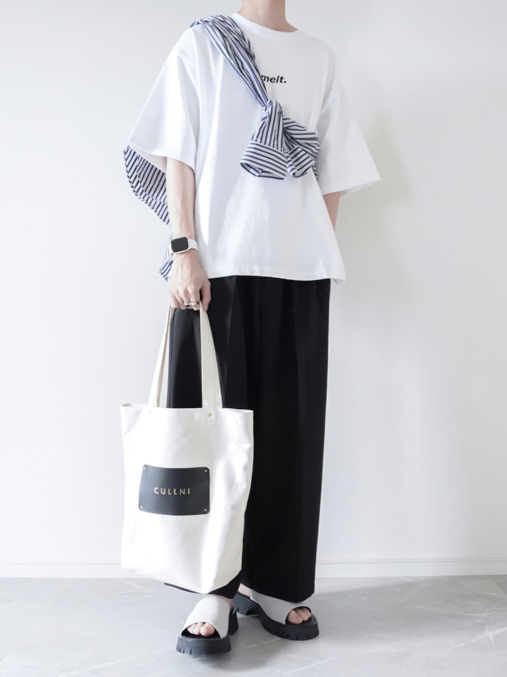 ホワイト系のTシャツ/カットソー、ブラック系のスラックス、グレー系のサンダルを着用したメンズの夏コーディネートの1枚目の写真