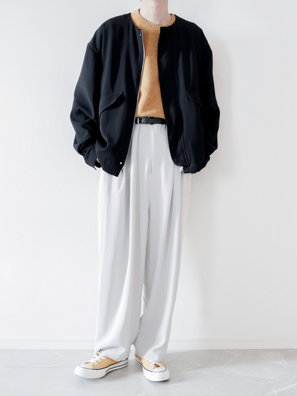 ブラック系のMA-1、イエロー系のニット/セーター、グレー系のその他パンツを着用したメンズの春コーディネートの1枚目の写真