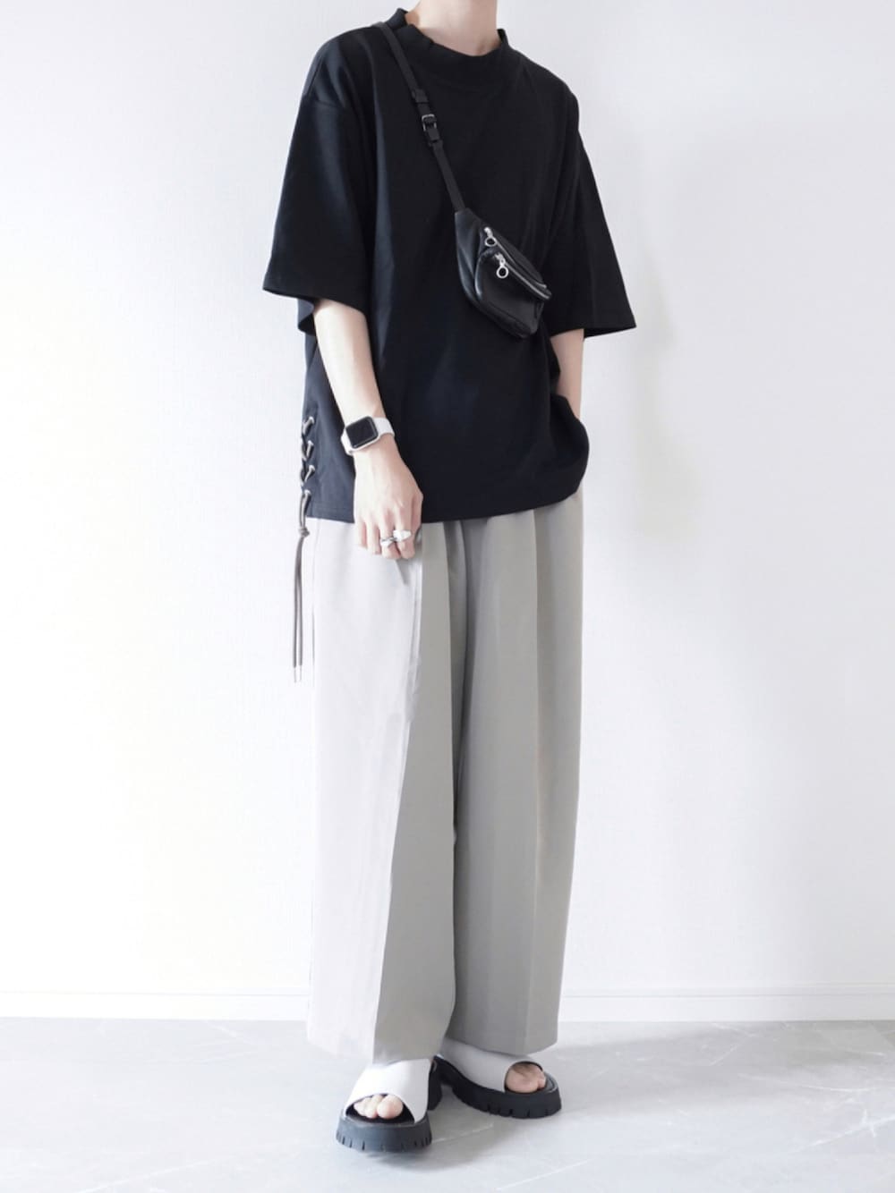 ブラック系のTシャツ/カットソー、グレー系のスラックス、グレー系のサンダルを着用したメンズの夏コーディネートの1枚目の写真