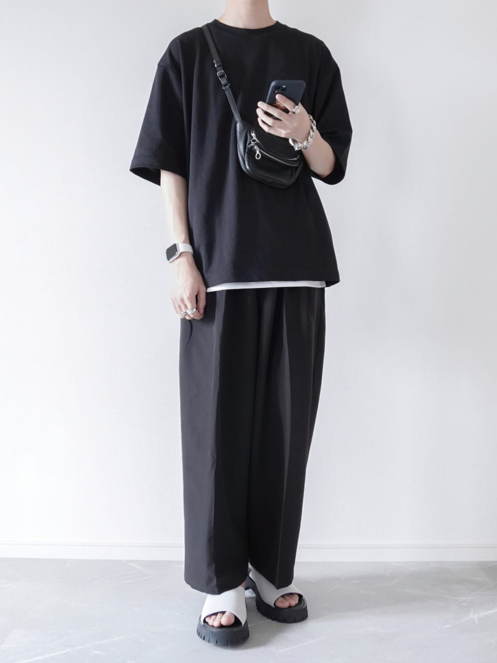 ブラック系のTシャツ/カットソー、ホワイト系のタンクトップ、ブラック系のスラックスを着用したメンズの夏コーディネートの1枚目の写真