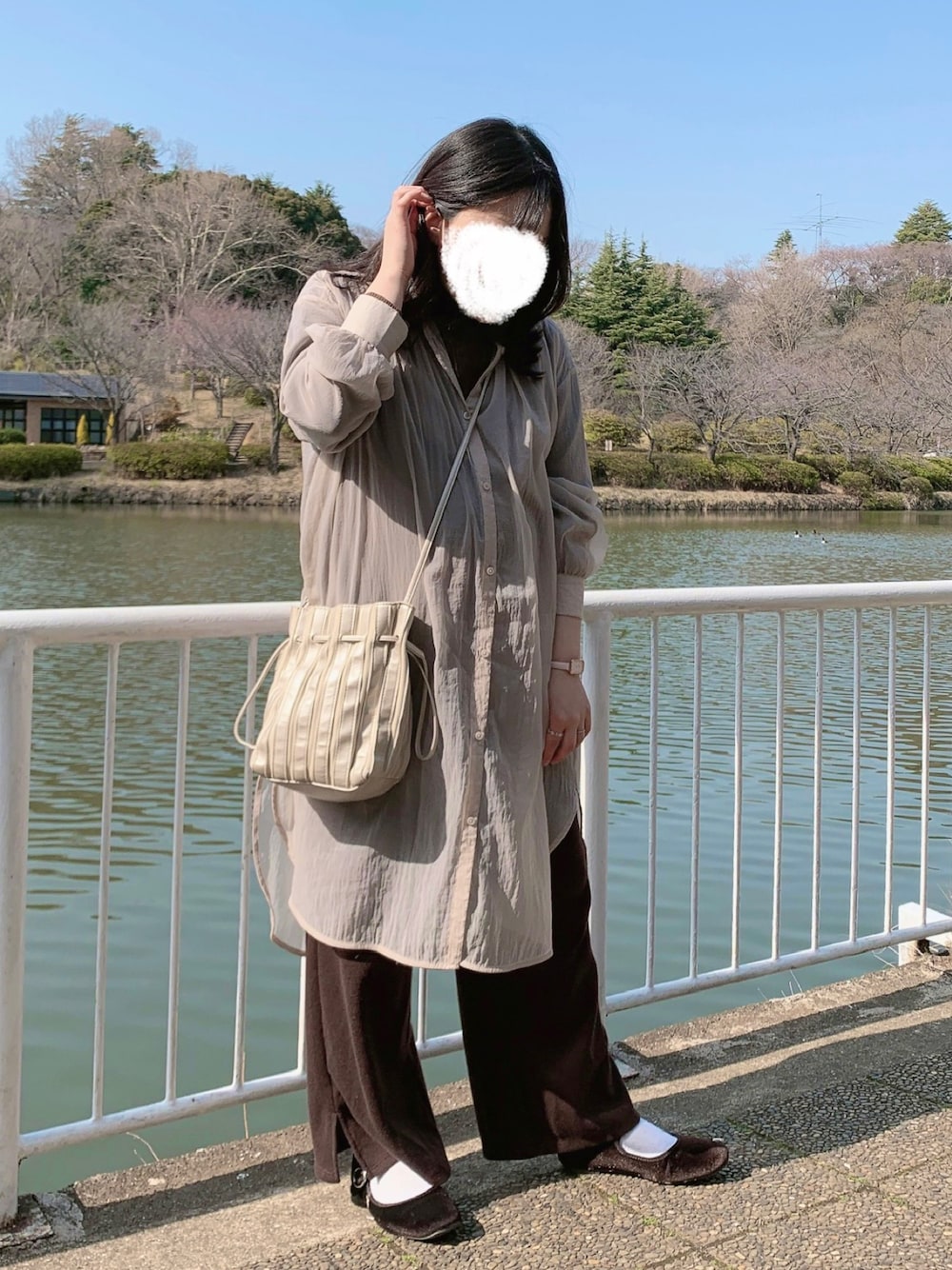 シルバー系のバッグ、ピンク系のシャツ/ブラウス、ブラウン系のパンツを着用したレディースの春コーディネートの1枚目の写真