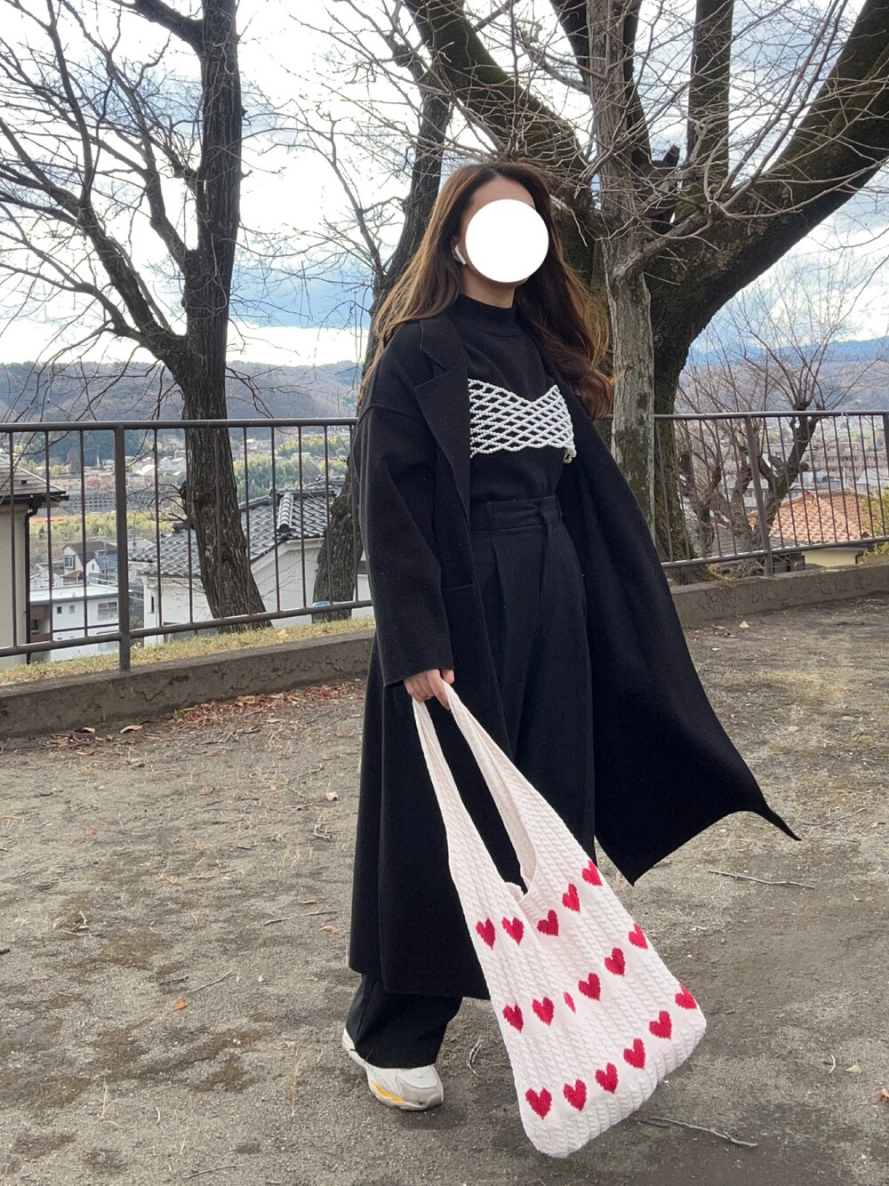 レッド系のトートバッグ、ブラック系のジャケット/アウター、ブラック系のパンツを着用したレディースの冬コーディネートの1枚目の写真