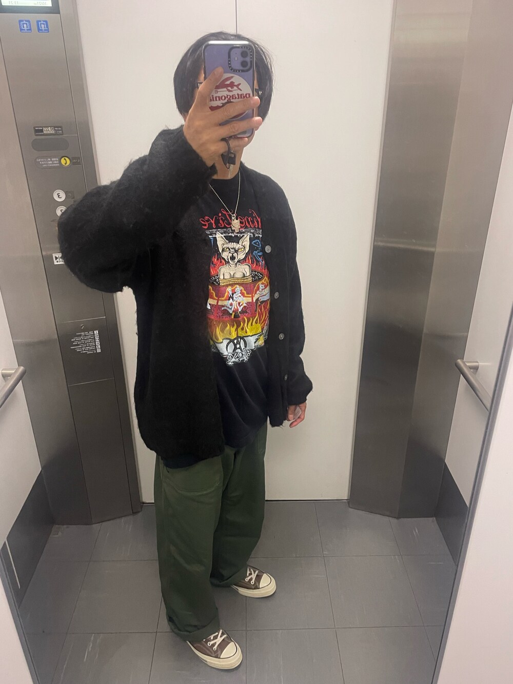 ブラウン系のスニーカー、グリーン系のカーゴパンツ、ブラック系のニット/セーターを着用したメンズの秋コーディネートの1枚目の写真