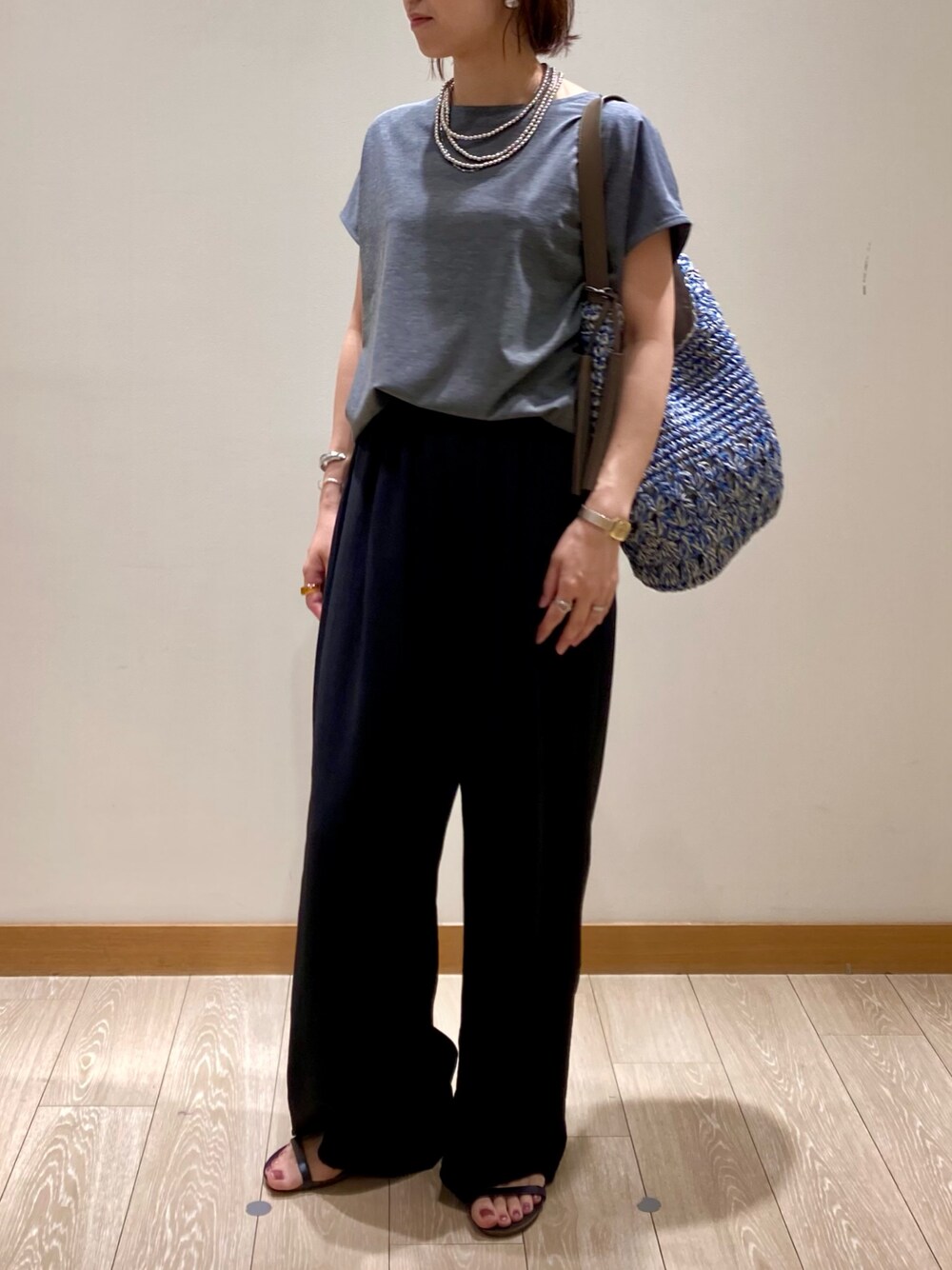 グレー系のTシャツ/カットソー、ブルー系のかごバッグ、ブラック系のその他パンツを着用したレディースの夏コーディネートの1枚目の写真