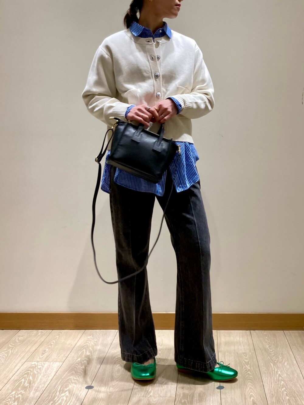 グリーン系のバレエシューズ、ブラック系のトートバッグ、ブラック系のデニムパンツを着用したレディースの冬コーディネートの1枚目の写真