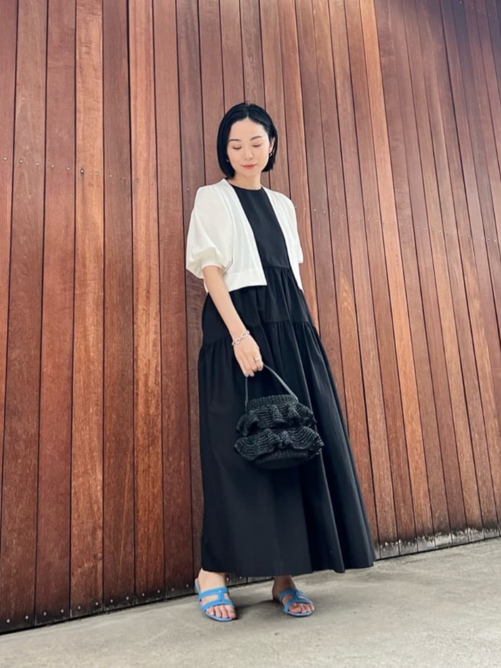 ブラック系のワンピース、ブラック系のかごバッグを着用したレディースの春コーディネートの1枚目の写真