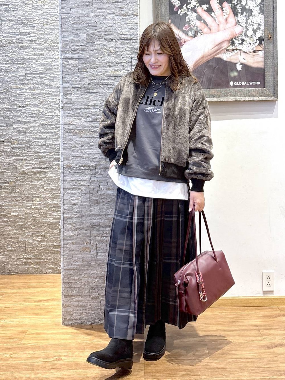 レッド系のボストンバッグ、ブラック系のブルゾン、ホワイト系のTシャツ/カットソーを着用したレディースの秋コーディネートの1枚目の写真