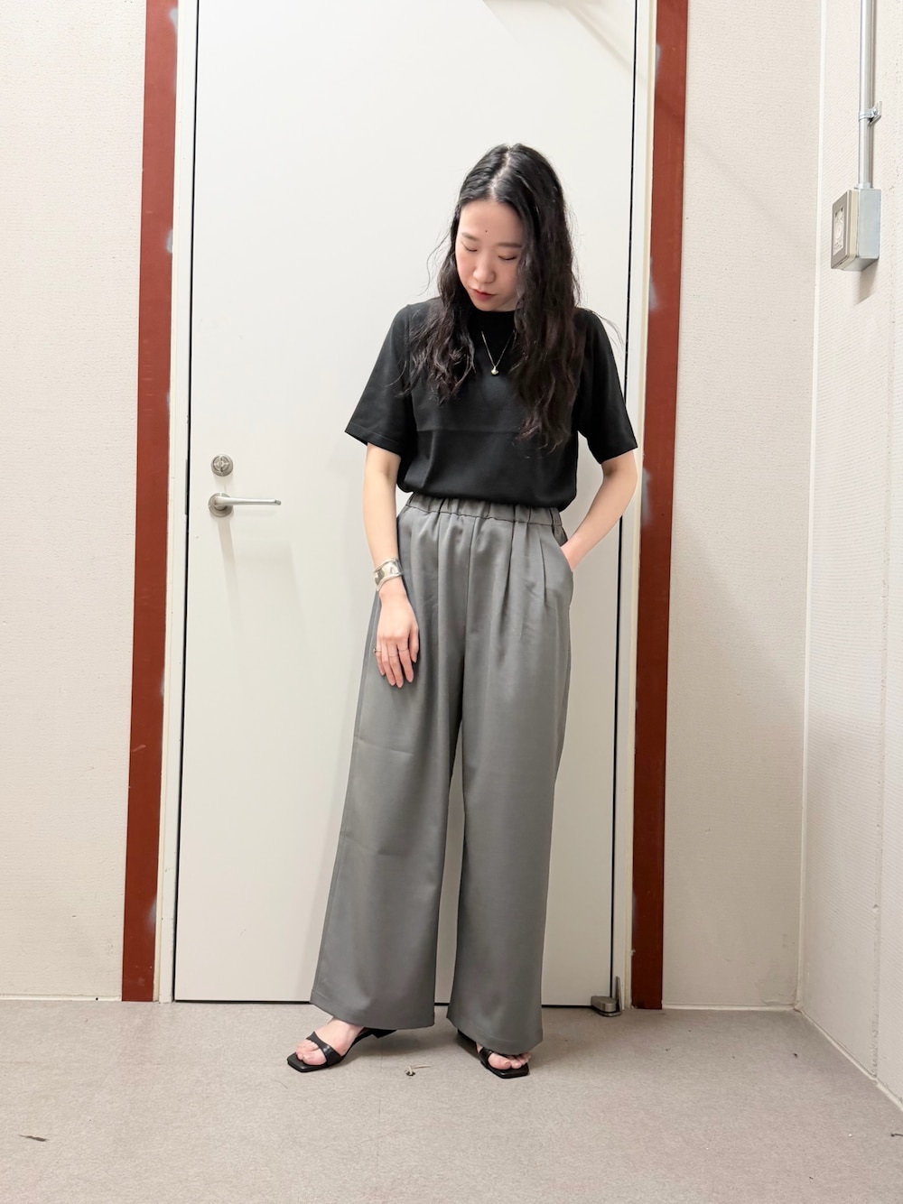 ブラック系のTシャツ/カットソー、グレー系のその他パンツ、ブラック系のサンダルを着用したレディースの春コーディネートの1枚目の写真