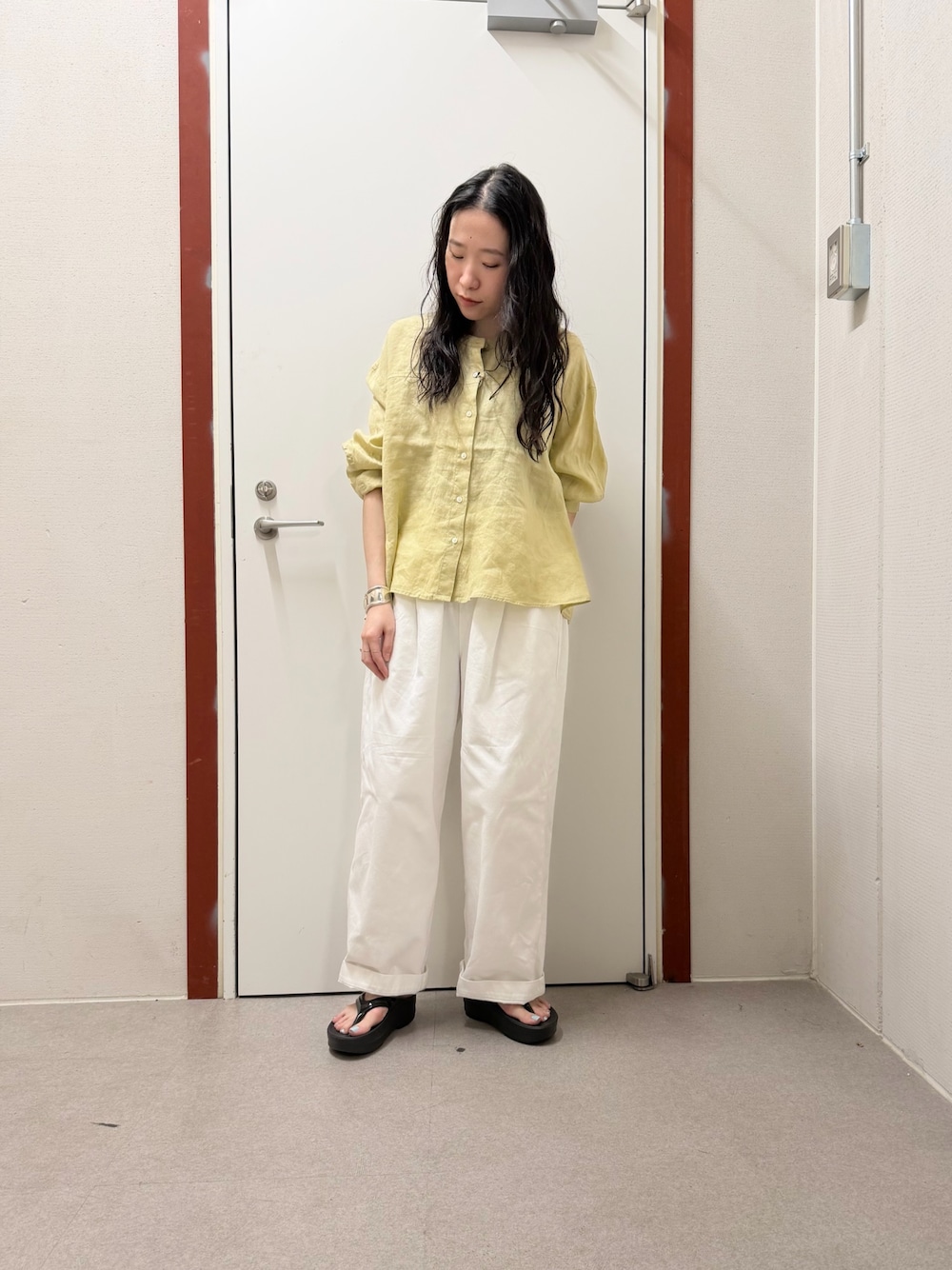 イエロー系のシャツ/ブラウス、ホワイト系のその他パンツ、ブラック系のサンダルを着用したレディースの春コーディネートの1枚目の写真