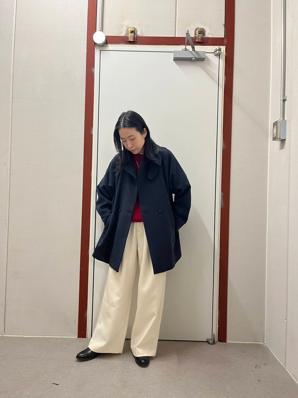 ブラック系のブーツ、レッド系のニット/セーター、ホワイト系のその他パンツを着用したレディースの冬コーディネートの1枚目の写真