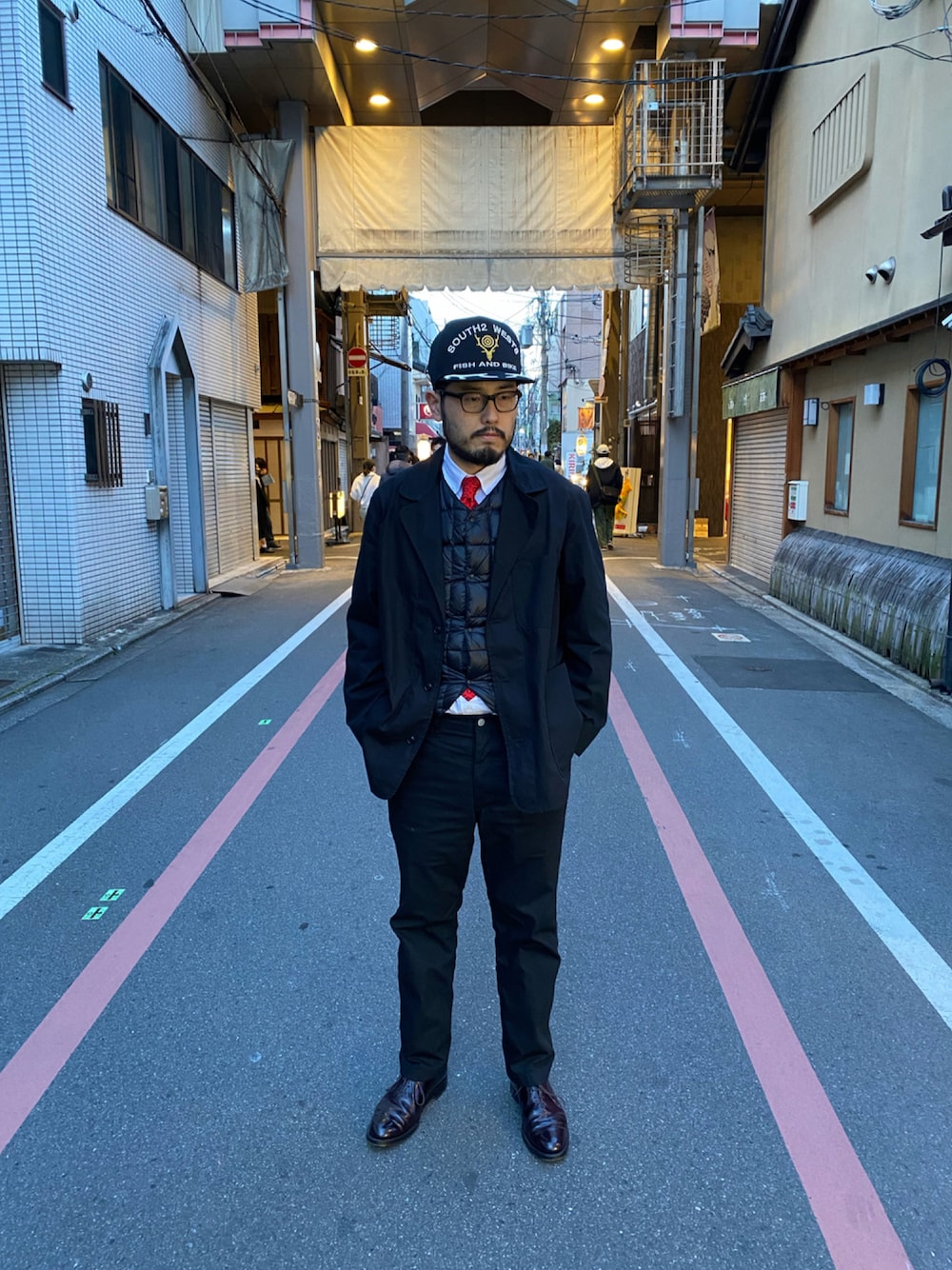 ブラック系のダウンベスト、ブラック系のテーラードジャケット、ブラック系のスラックスを着用したメンズの夏コーディネートの1枚目の写真