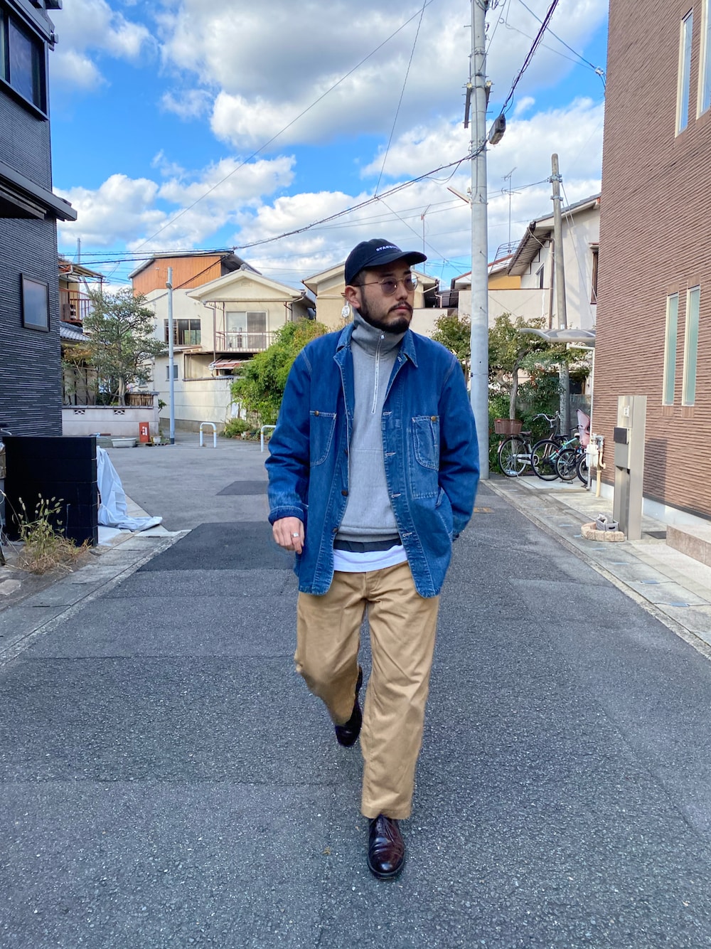 ブルー系のカバーオール、グレー系のスウェット、ベージュ系のチノパンツを着用したメンズの冬コーディネートの1枚目の写真