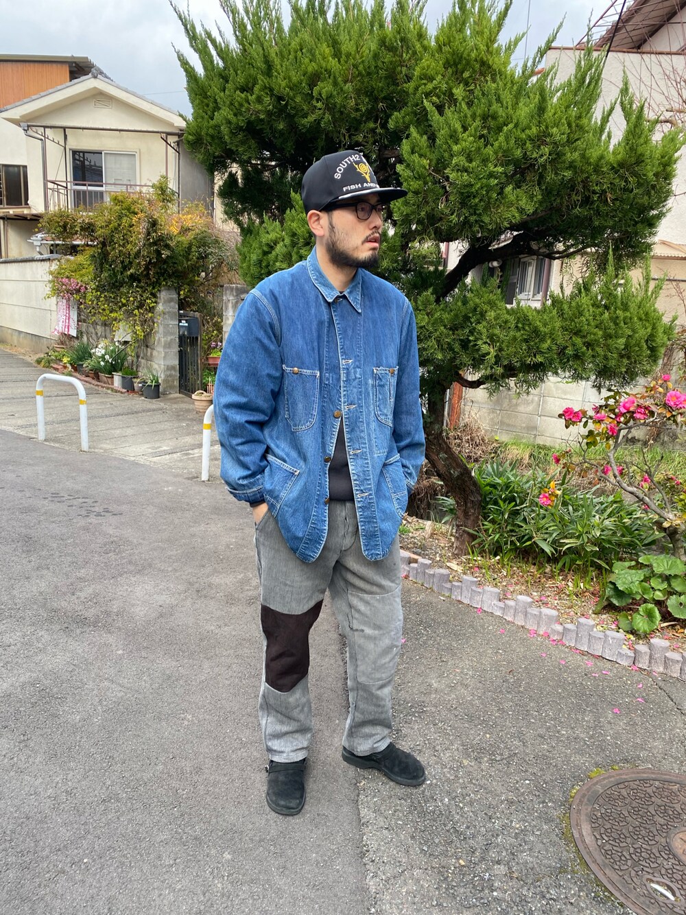 ブルー系のカバーオール、グレー系のパンツ、ブラック系のスリッポンを着用したメンズの夏コーディネートの1枚目の写真