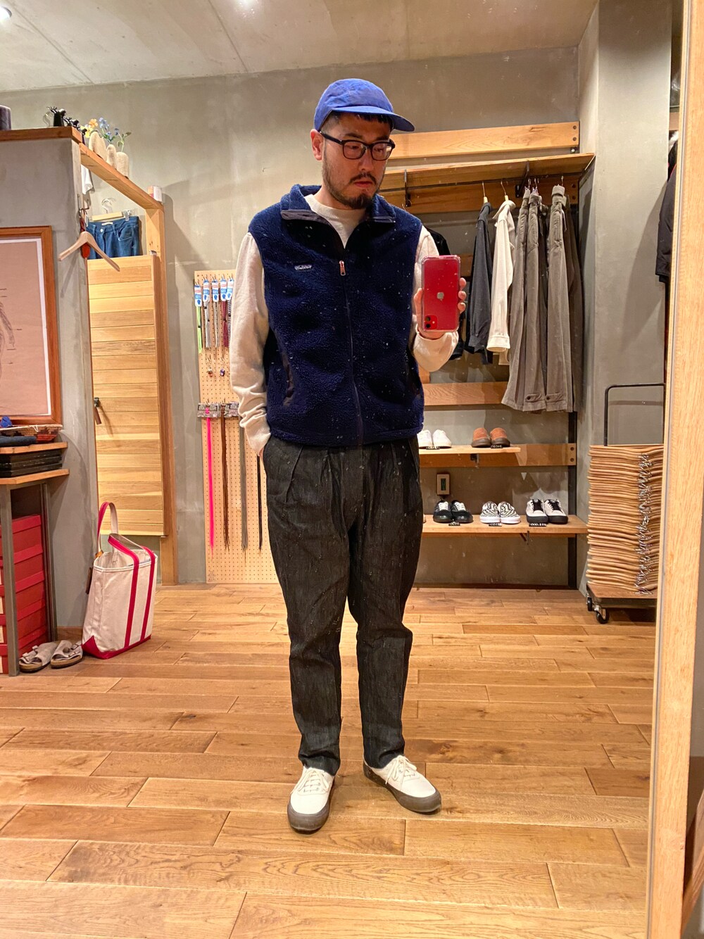 ブルー系のベスト、ホワイト系のニット/セーター、ブラック系のデニムパンツを着用したメンズの夏コーディネートの1枚目の写真