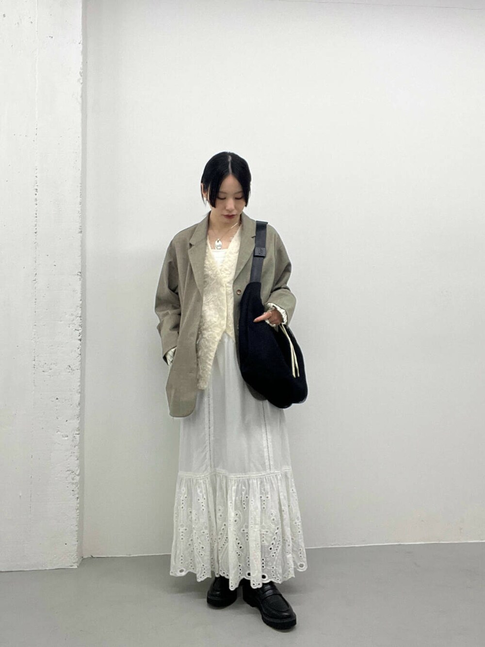 ブラック系のローファー、ベージュ系のその他アウター、ホワイト系のベストを着用したレディースの春コーディネートの1枚目の写真