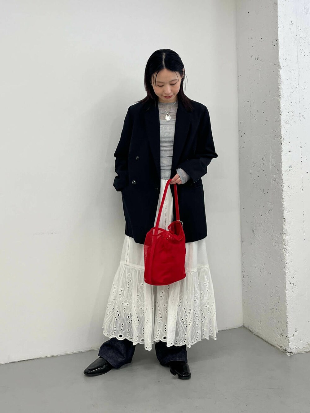 ブラック系のローファー、ブラック系のその他アウター、レッド系のショルダーバッグを着用したレディースの春コーディネートの1枚目の写真