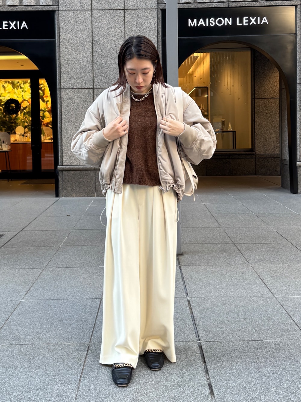 イエロー系のスラックス、ベージュ系のMA-1、ブラウン系のニット/セーターを着用したレディースの秋コーディネートの1枚目の写真