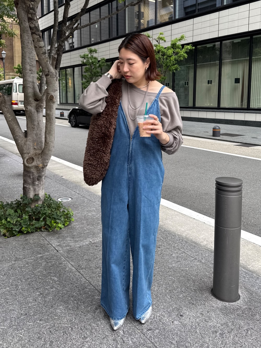 ブルー系のつなぎ/オールインワン、ベージュ系のスウェット、ブラウン系のショルダーバッグを着用したレディースの秋コーディネートの1枚目の写真