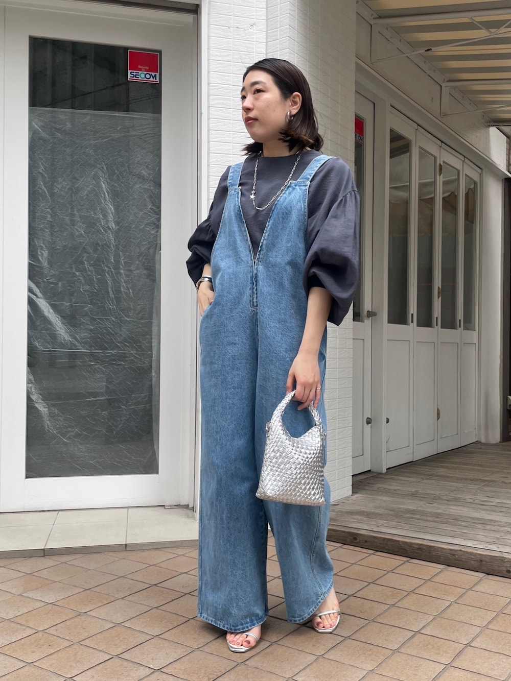 ブルー系のシャツ/ブラウス、ブルー系のサロペット/オーバーオール、シルバー系のショルダーバッグを着用したレディースの春コーディネートの1枚目の写真