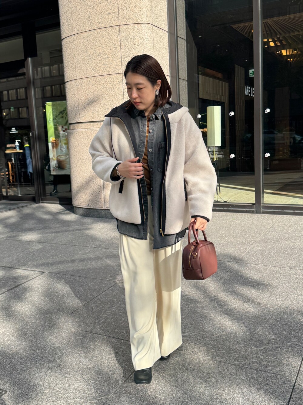 ホワイト系のその他アウター、ブルー系のシャツ/ブラウス、ブラウン系のTシャツ/カットソーを着用したレディースの秋コーディネートの1枚目の写真