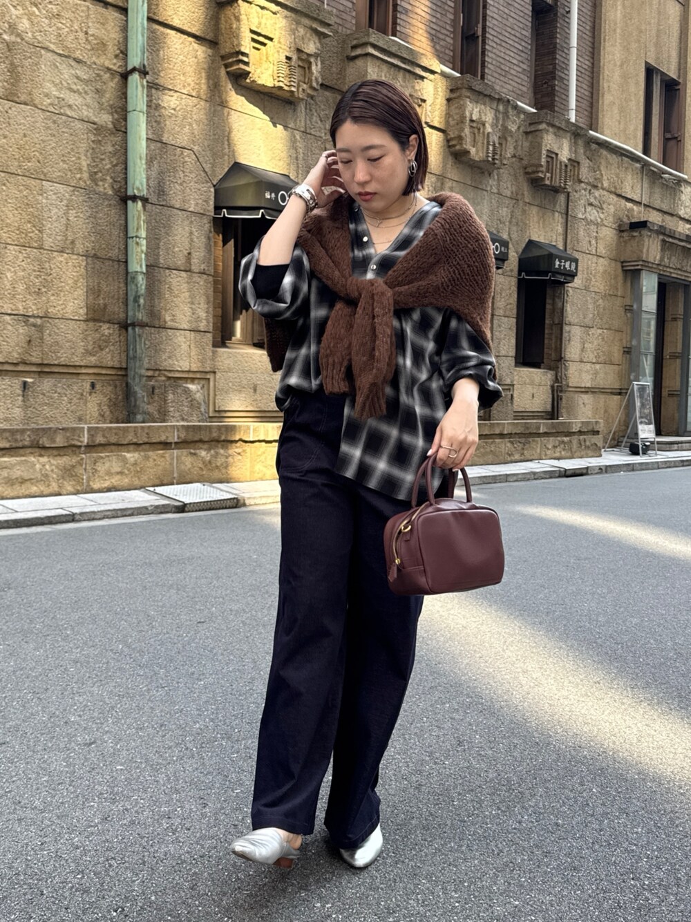 ブラック系のその他パンツ、ブラック系のシャツ/ブラウス、ブラウン系のニット/セーターを着用したレディースの秋コーディネートの1枚目の写真
