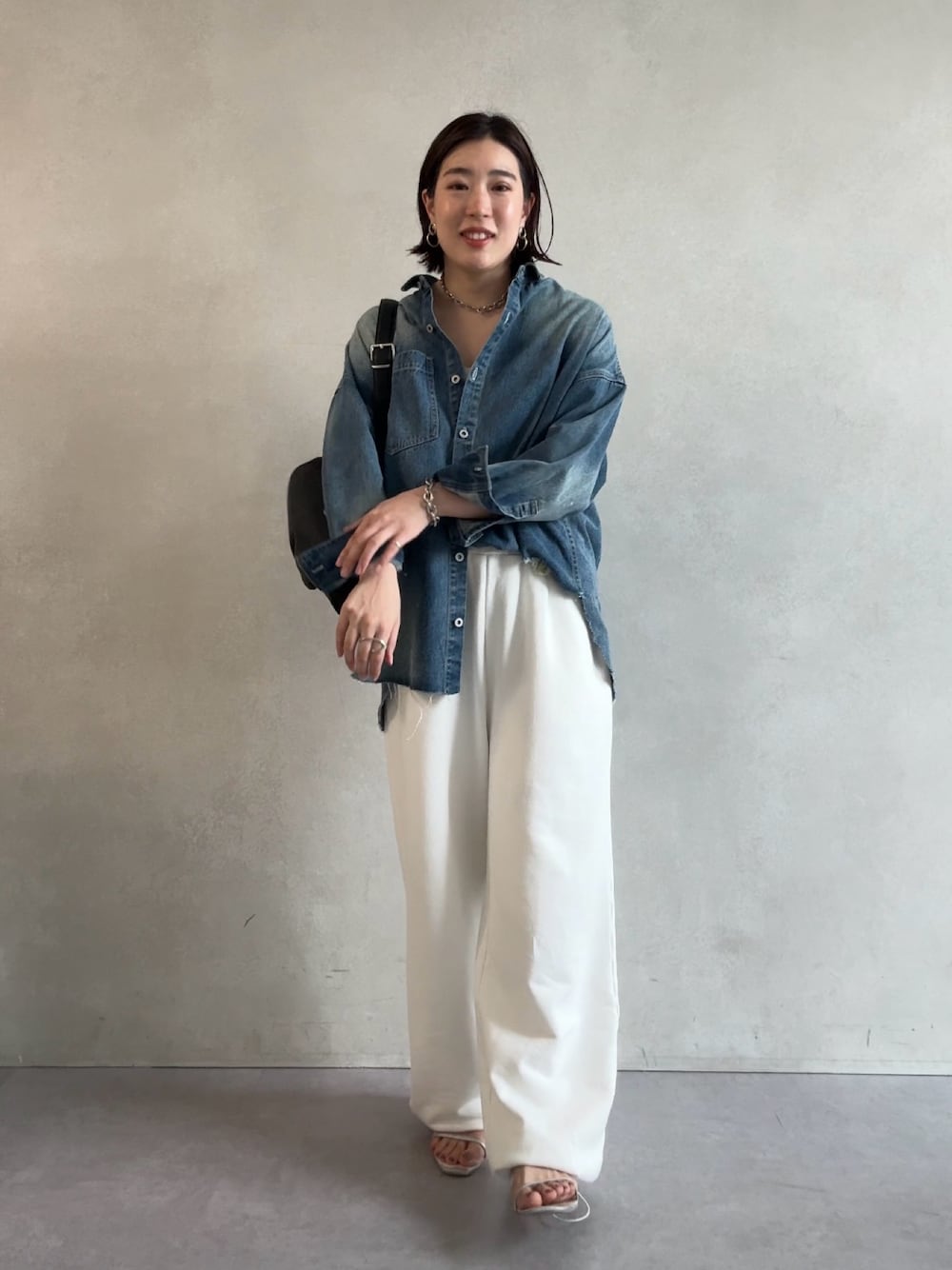 ホワイト系のスウェットパンツ、ブルー系のシャツ/ブラウス、ブラック系のショルダーバッグを着用したレディースの秋コーディネートの1枚目の写真