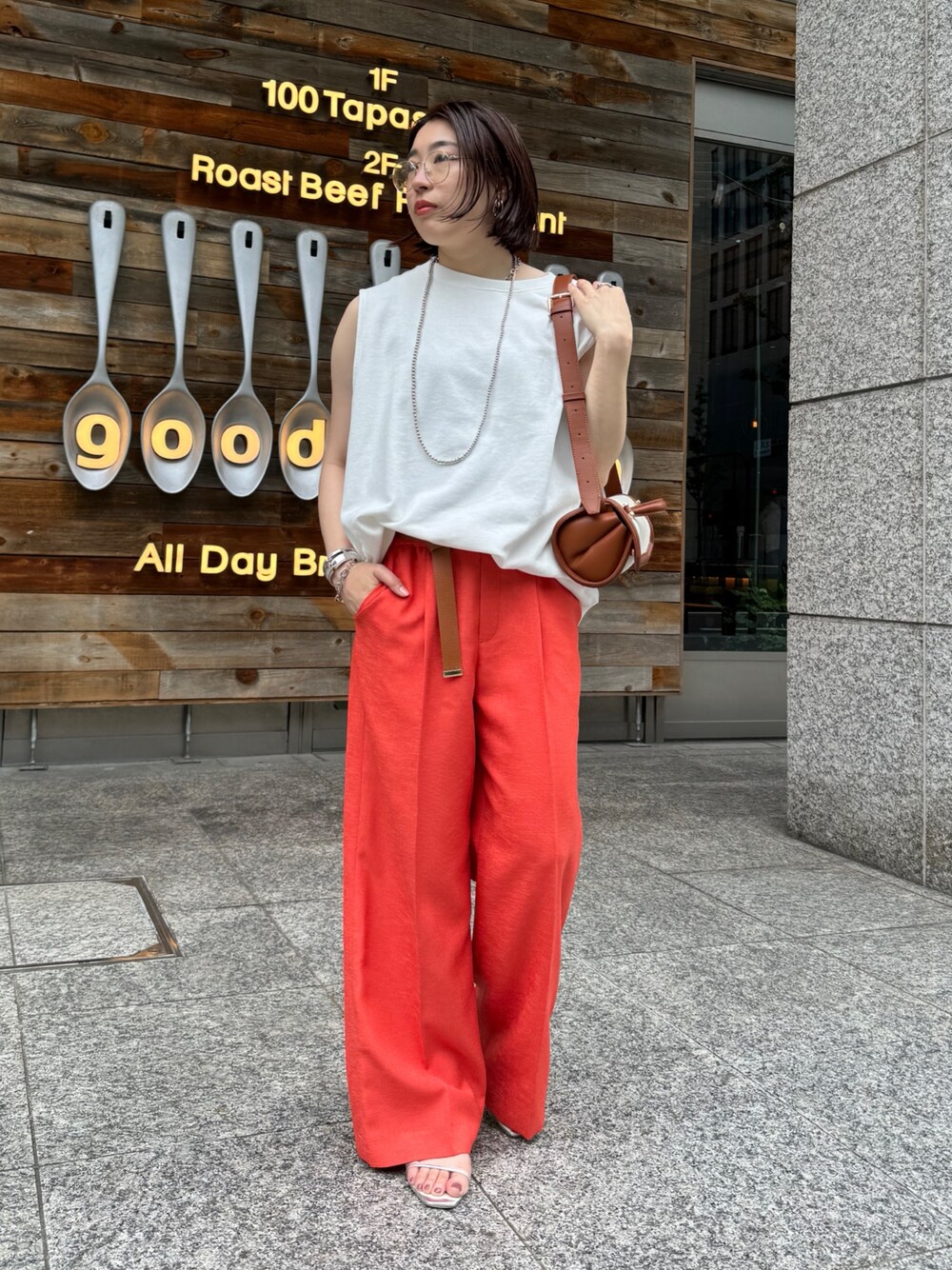 オレンジ系のその他パンツ、ホワイト系のスウェット、ブラウン系のショルダーバッグを着用したレディースの夏コーディネートの1枚目の写真