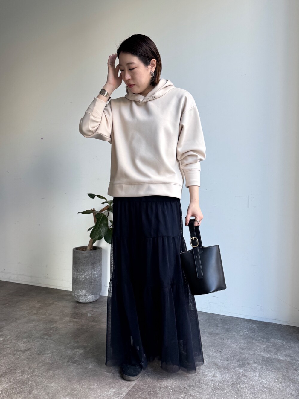 ホワイト系のセットアップ、ブルー系のスカートを着用したレディースの冬コーディネートの1枚目の写真