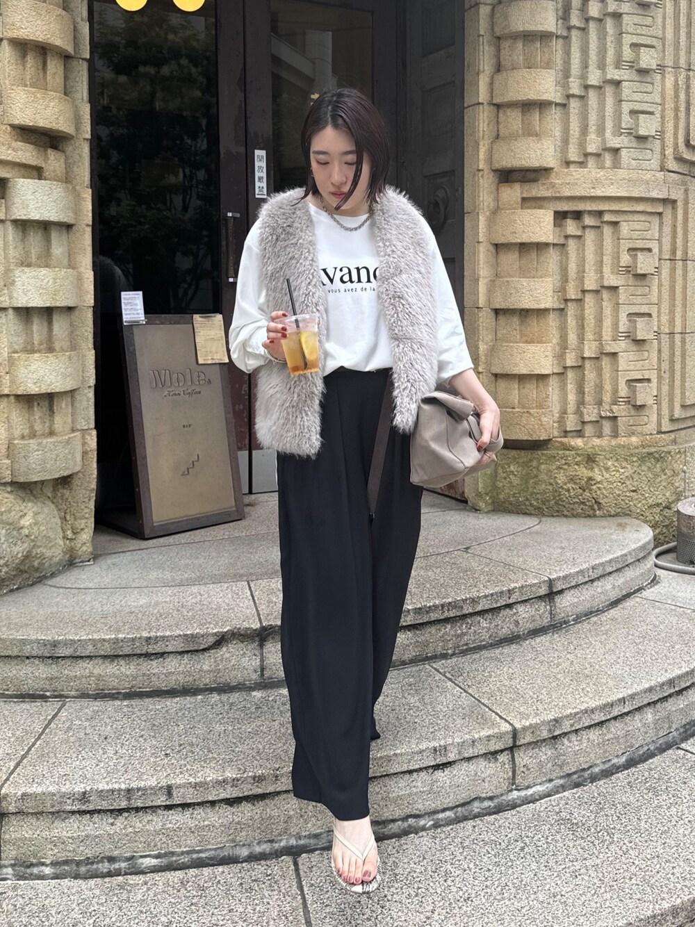 ブラック系のスラックス、グレー系のベスト、ホワイト系のTシャツ/カットソーを着用したレディースの夏コーディネートの1枚目の写真