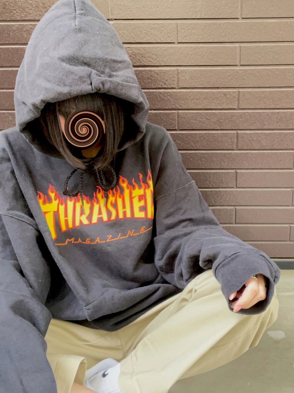 ブラック系のパーカー、ベージュ系のチノパンツ、ホワイト系のスニーカーを着用したレディースの秋コーディネートの1枚目の写真