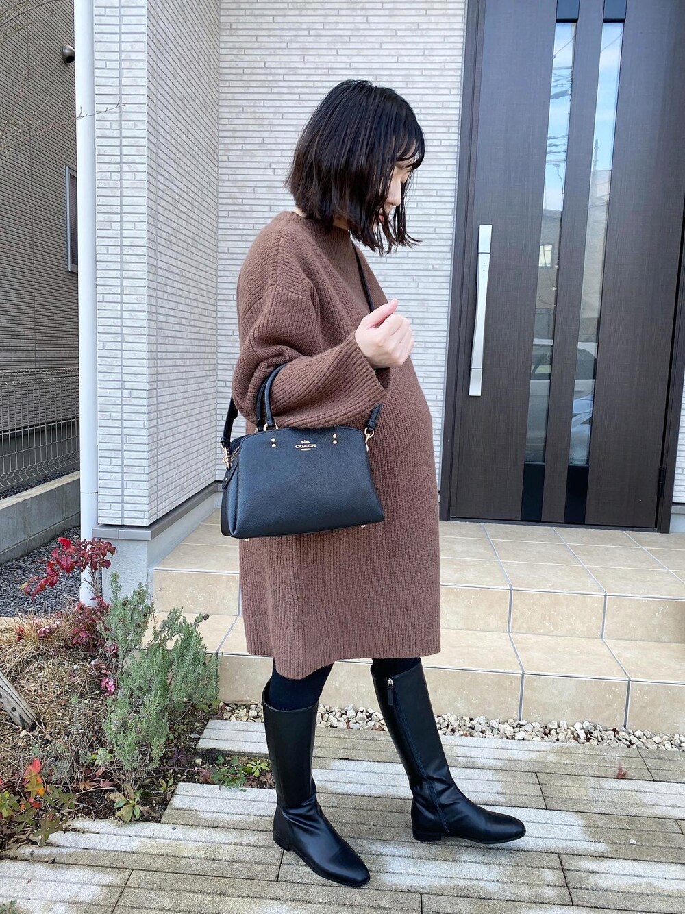 「妊婦コーデ、女の子ママ、臨月、ロングブーツ、ニットワンピース、ブラウン、ブーツ、冬コーデ、大人カジュアル、シンプルスタイル、カジュアルコーデ、大人可愛い、お出かけコーデ、オトナ女子、秋冬コーデ」｜「COACHのアイテム（ショルダーバッグ、ブラック系）」を使った、AYUMIさん（レディース・157cm）の冬コーディネートの1枚目の写真