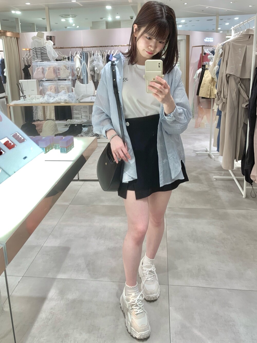 ブラック系のその他パンツ、ブラック系のショルダーバッグ、ブルー系のシャツ/ブラウスを着用したレディースの春コーディネートの1枚目の写真